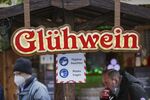 Visitors to a Christmas market wear face masks near a bar selling Gluhwein in Frankfurt, Germany, on Monday, Nov. 22, 2021.