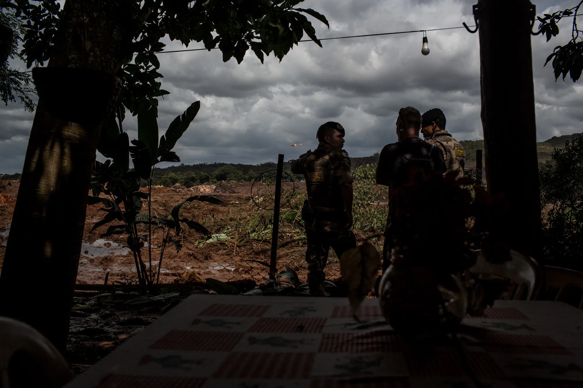 Police speak with a resident while observing damage caused by Vale dam rupture.