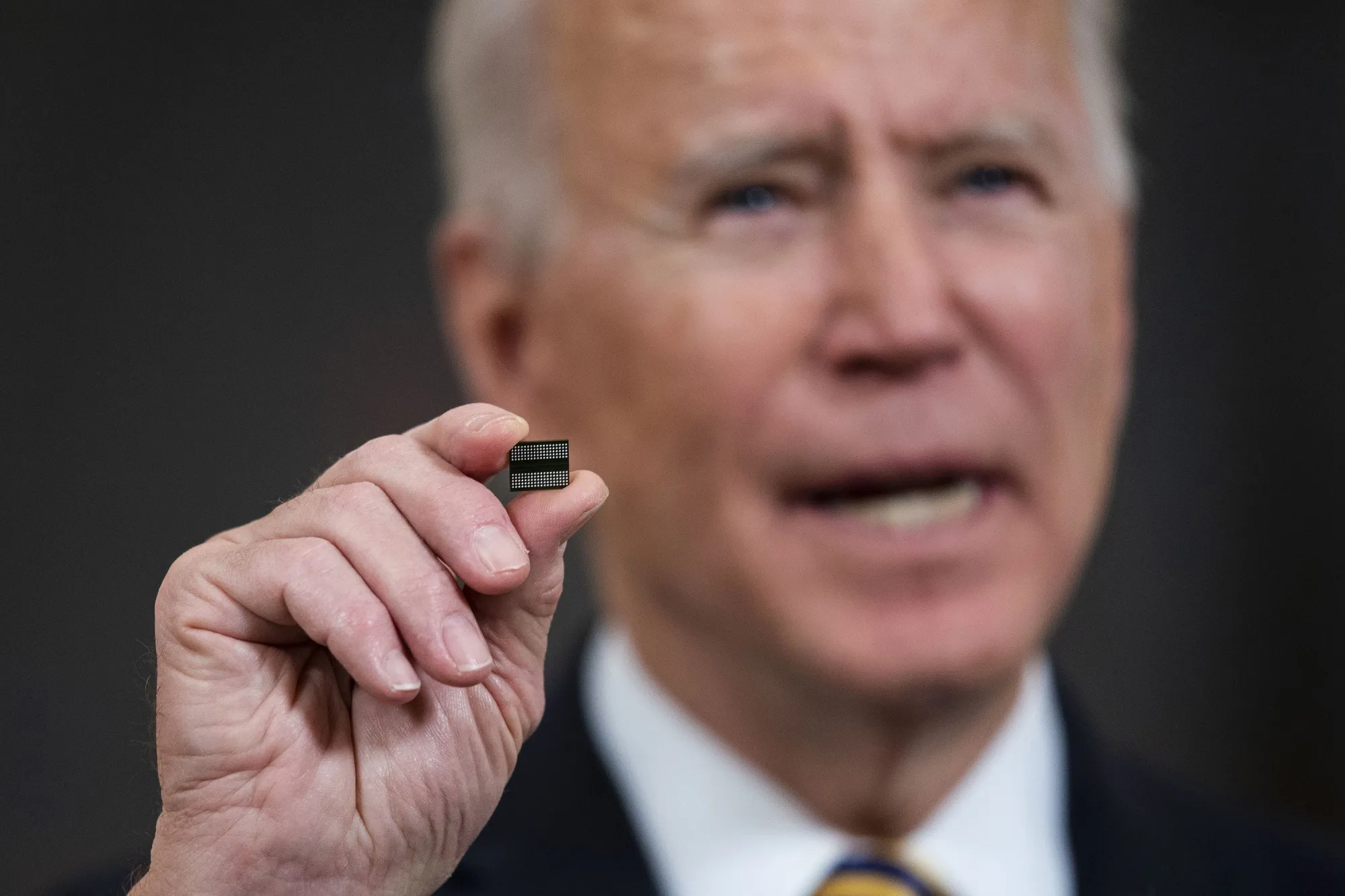 Joe Biden holds a semiconductor in Washington, DC.&nbsp;
