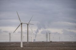 Wind turbines in front of a coal-fired power plant on the outskirts of the new city area of Yumen,&nbsp;China.