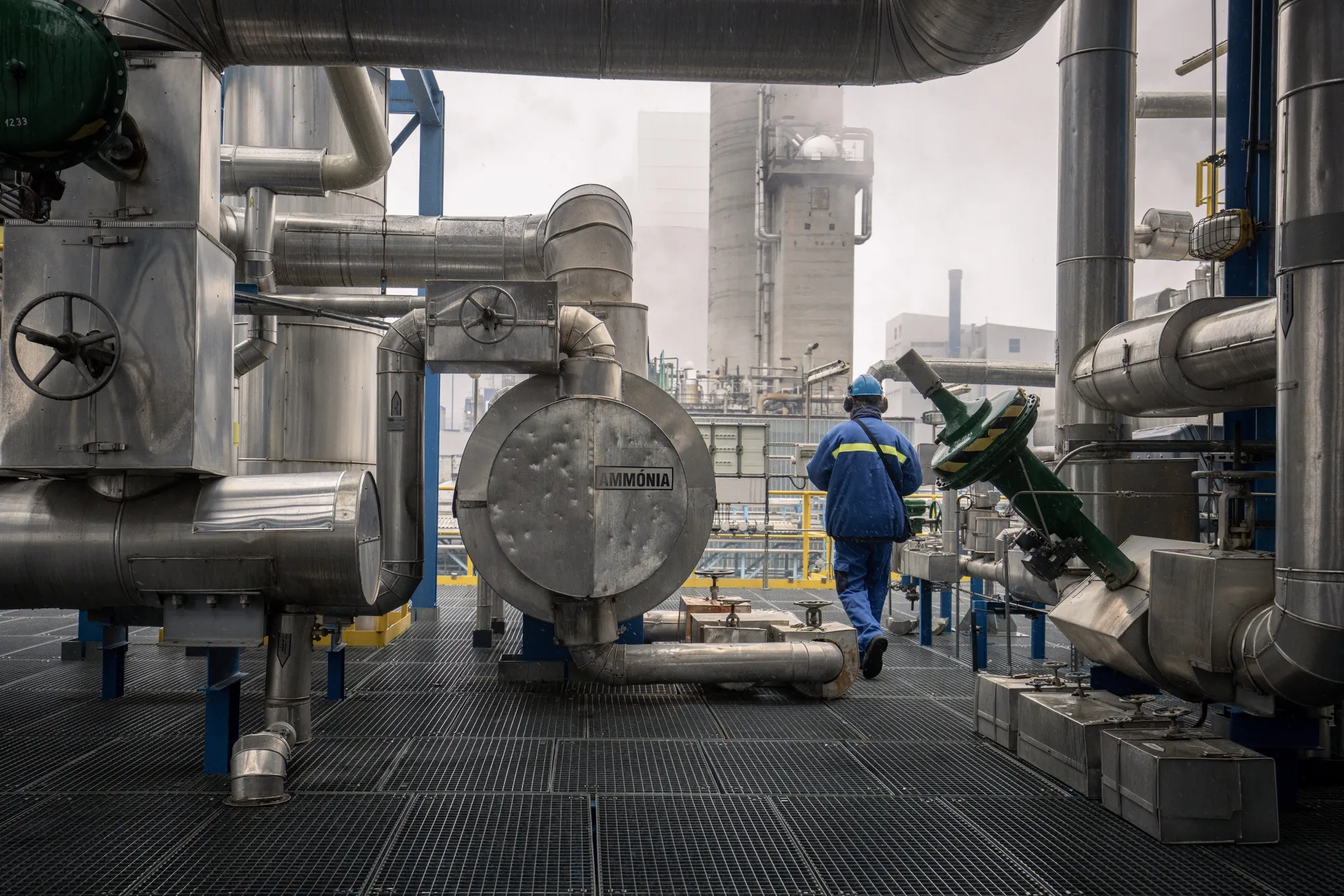 A worker passes an ammonia tank at the Nitrogenmuvek&nbsp;fertilizer plant in Petfurdo, Hungary, in December 2022.&nbsp;