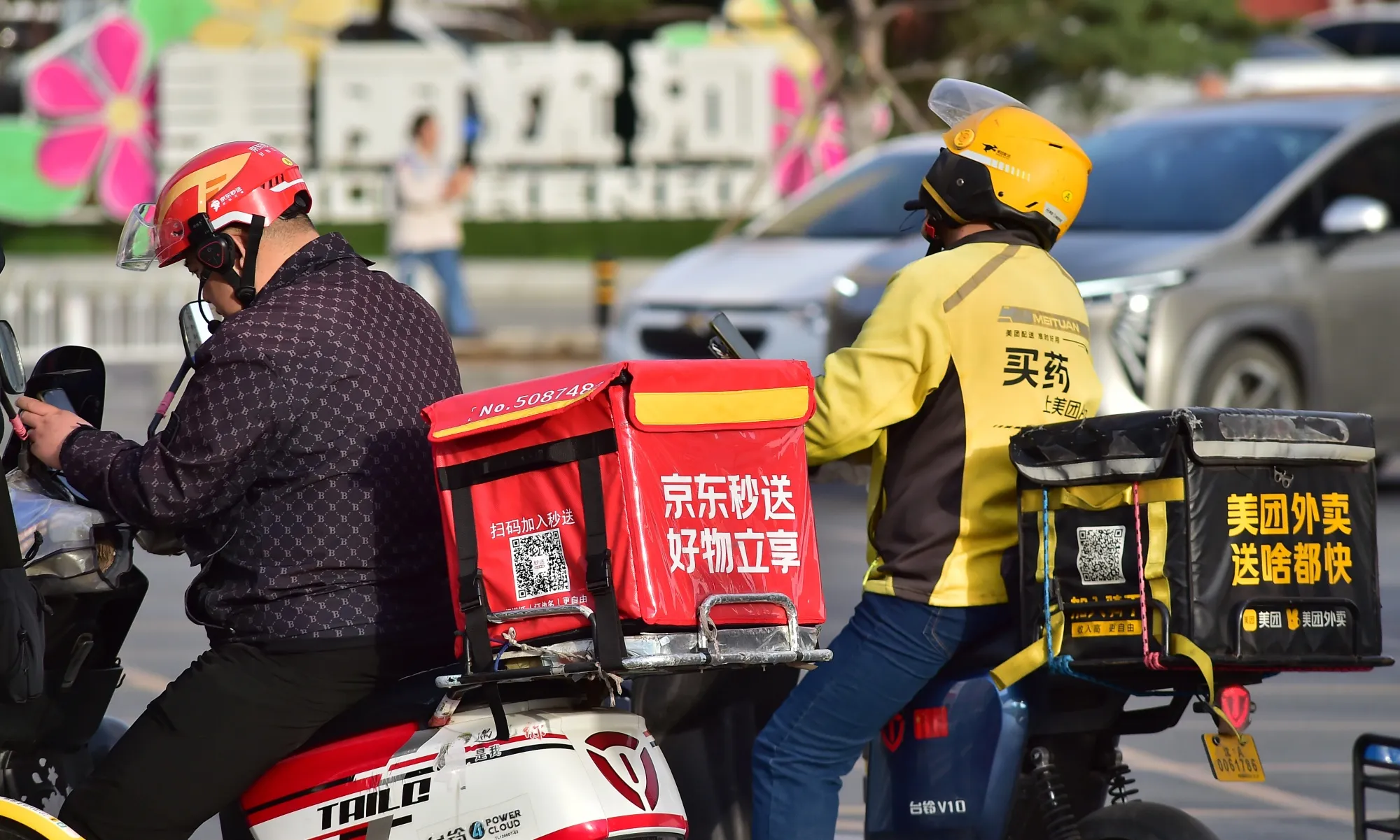 Food delivery riders of JD Takeaway, left, and Meituan in Shenyang, China, in April 2025.