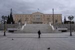 A pedestrian wearing a protective face mask walks past the Greek parliament building in Athens.