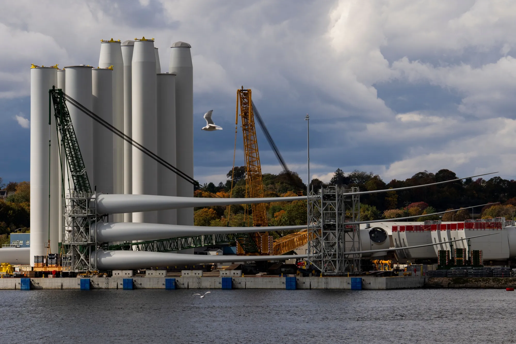 Wind turbine tower sections and blades at the Revolution Wind project assembly site at State Pier in New London, Connecticut, in&nbsp;2025.