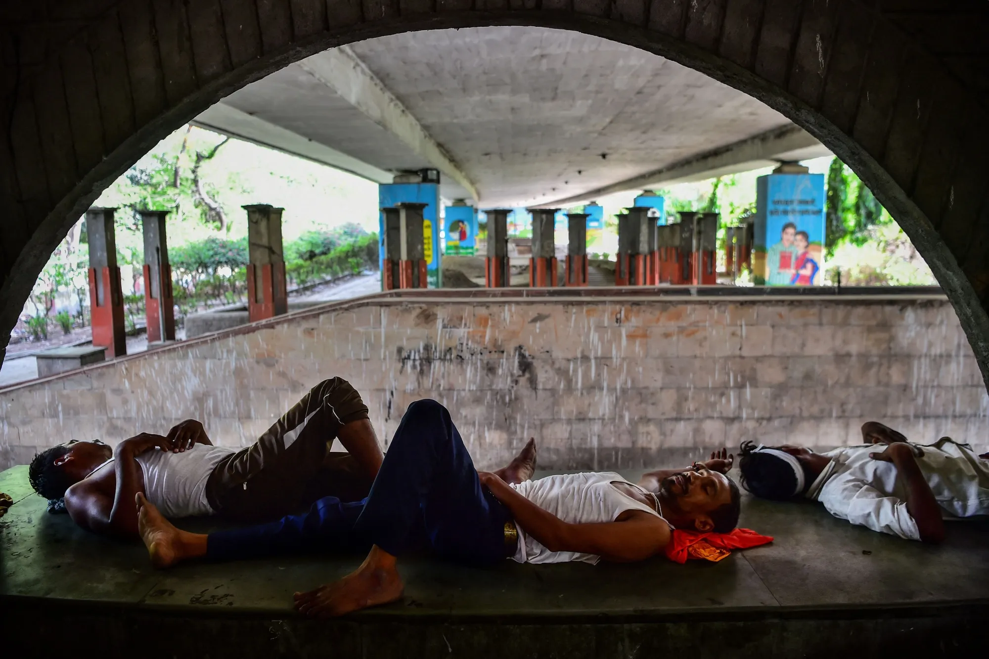 People shelter under a bridge during a hot summer day in Allahabad, India.