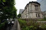 Pedestrians walk past the Bank of Japan&nbsp;headquarters in Tokyo.