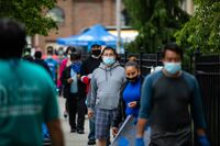 People wearing protective masks wait in line outside a Catholic Charities Brooklyn and Queens pop-up food pantry in the Brooklyn borough of New York on May 29.