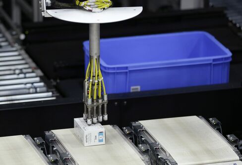 An industrial robot places an item on a conveyor