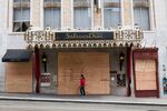A pedestrian walks past a boarded up St. Francis Drake Hotel in San Francisco.