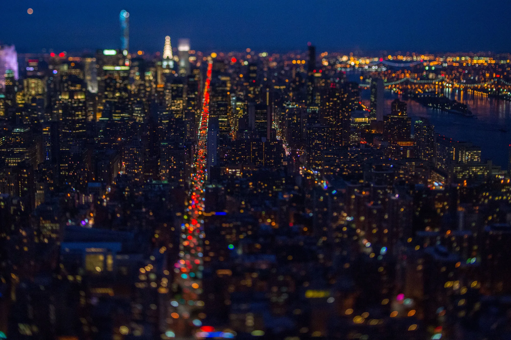 Traffic moves along Third Avenue in Manhattan at dusk in this aerial photograph taken with a tilt-shift lens above New York, U.S.