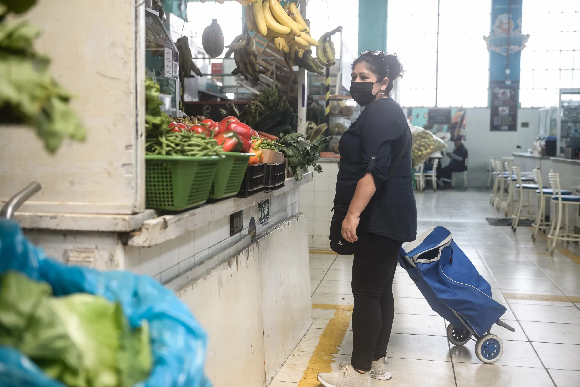 A shopper browses produce at a market in Lima, Peru.
