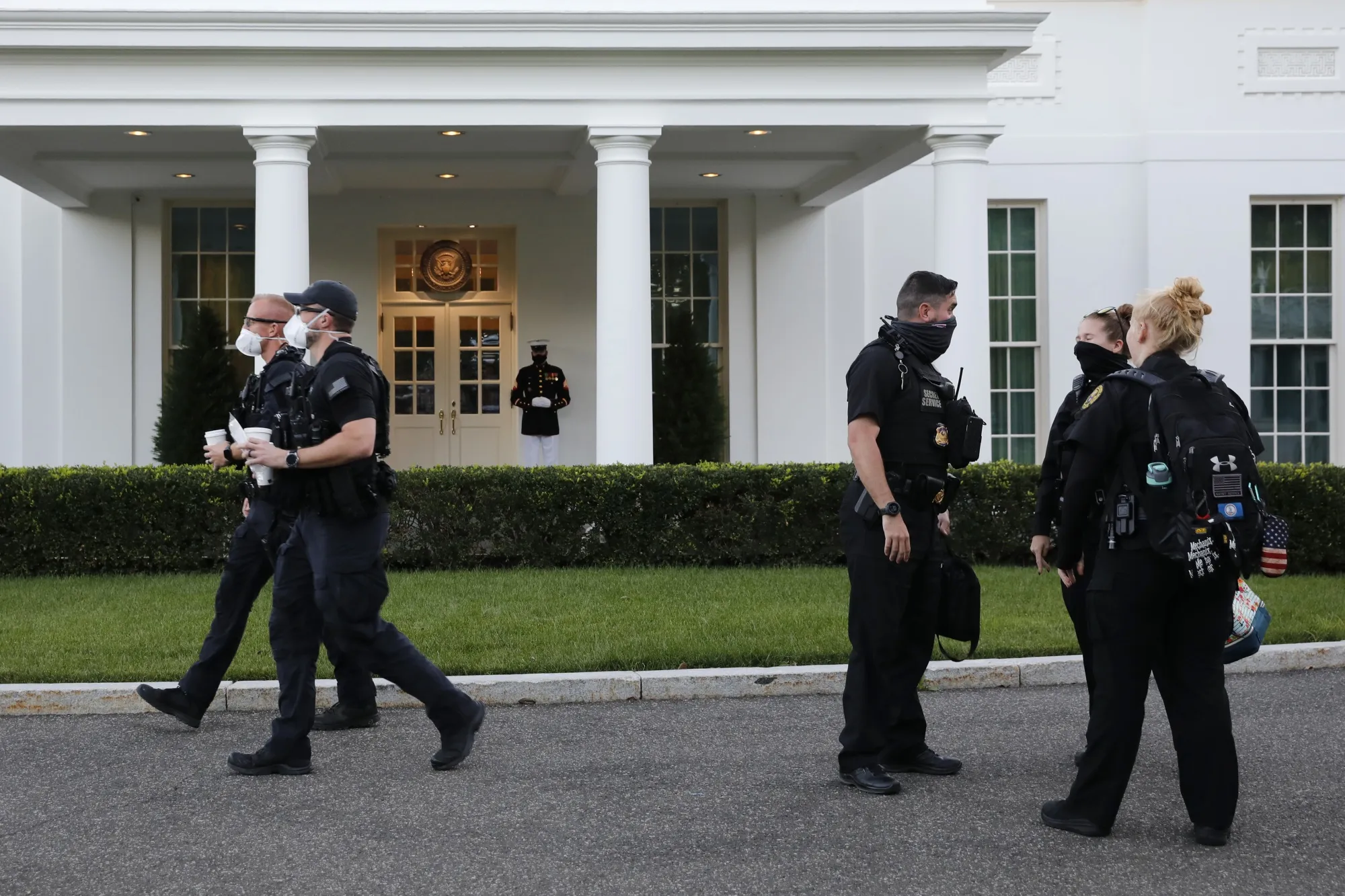 A Marine and members of the U.S. Secret Service wear protective masks outside of the West Wing of the White House on&nbsp;Oct. 8.&nbsp;