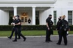 A Marine and members of the U.S. Secret Service wear protective masks outside of the West Wing of the White House on Oct. 8. 