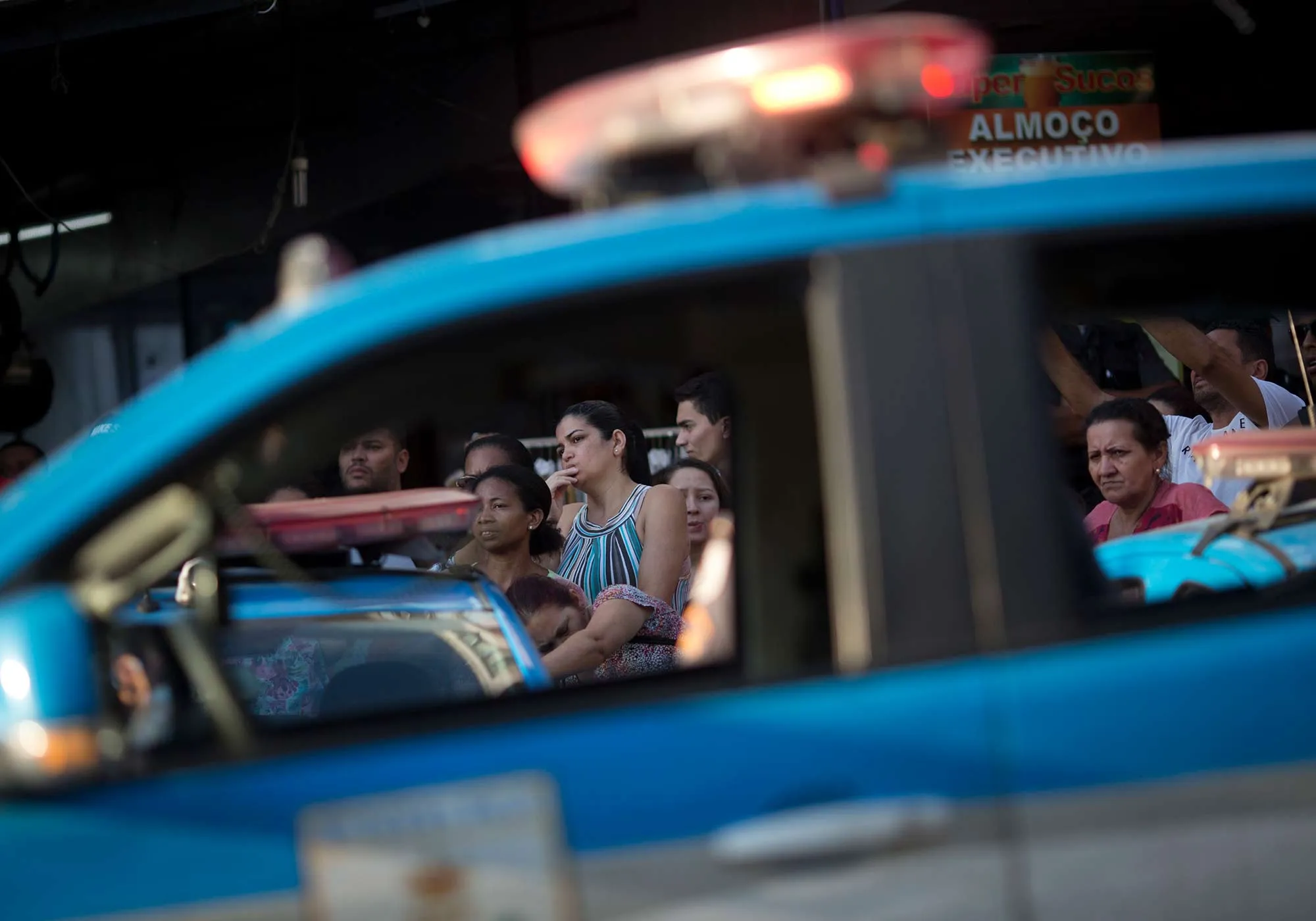 Protesters listen to a community leader talk about police violence, during police operations in the Rocinha slum of Rio de Janeiro, Brazil, on Oct. 19, 2017.
