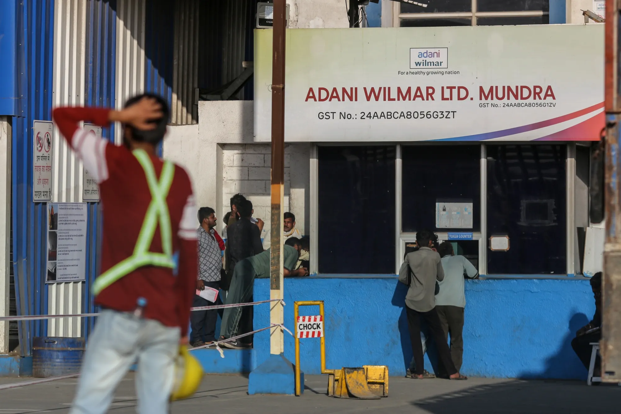 Workers outside the Adani Wilmar Ltd. edible oil manufacturing unit in Mundra, Gujarat, India.