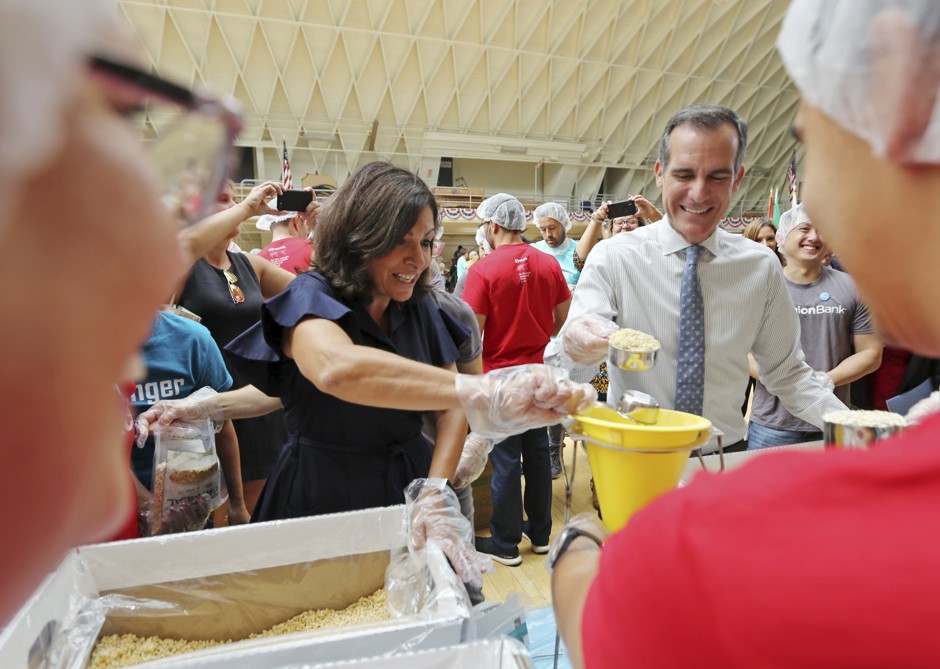 Paris Mayor Anne Hidalgo and Los Angeles Mayor Eric Garcetti help pack lunches for the needy. They met Tuesday ahead of the global climate summit that began Wednesday in San Francisco.