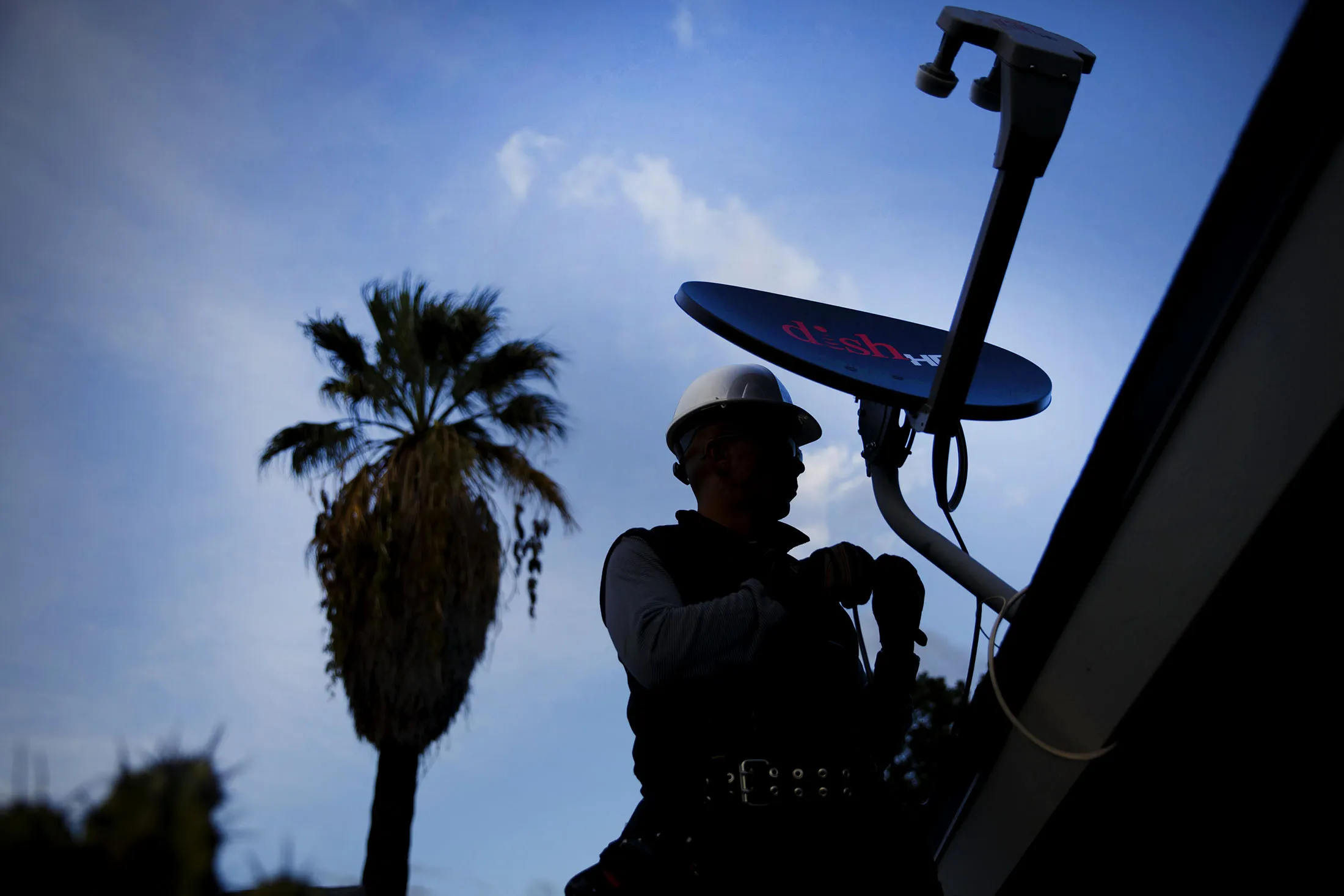 A Dish Network Corp. field service specialist installs a satellite television system.
