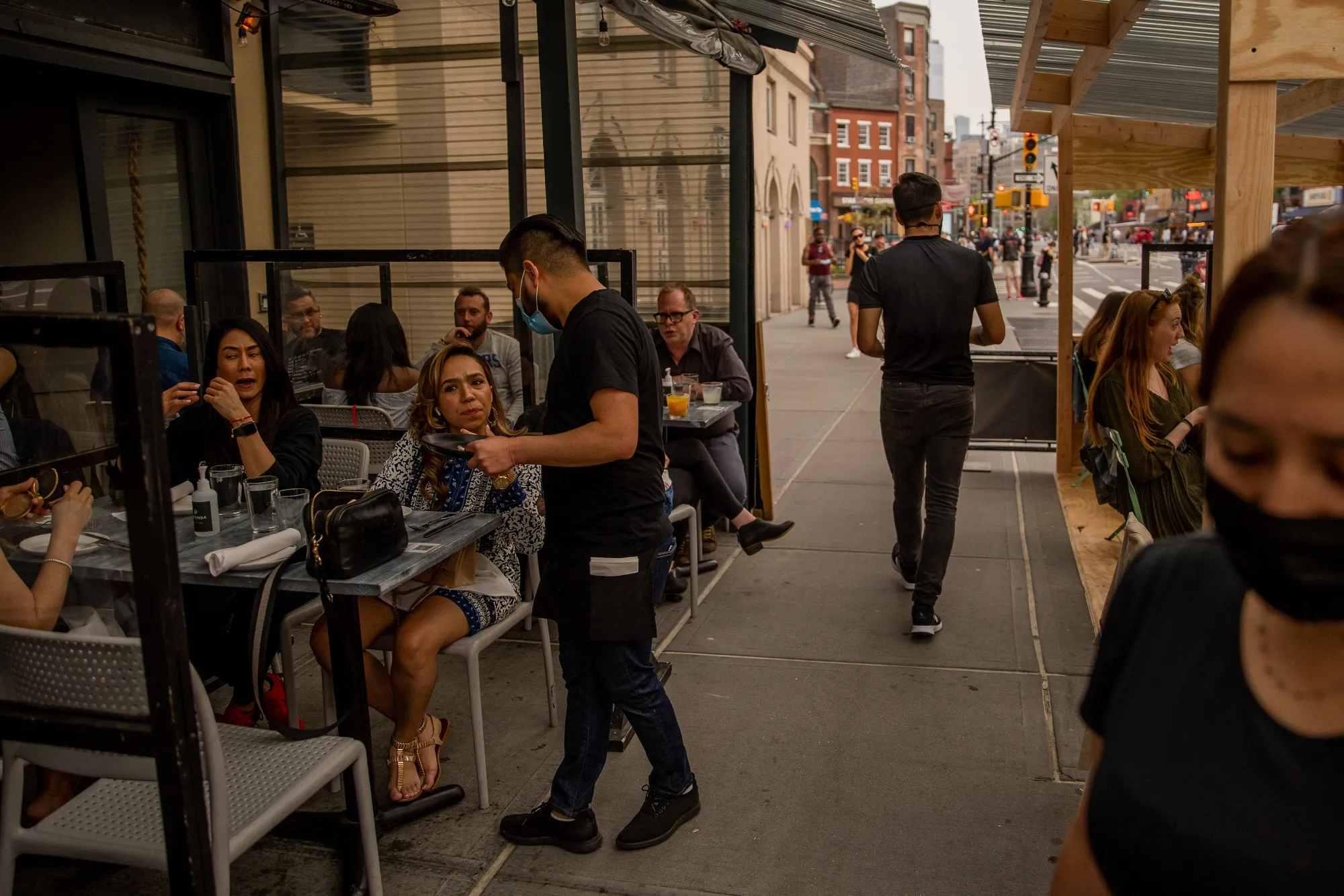 Servers assisting customers outside of a busy&nbsp;restaurant in the West Village neighborhood of New York, on April 28.
