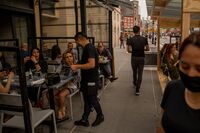 Servers assisting customers outside of a busy restaurant in the West Village neighborhood of New York, on April 28.