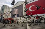 Pigeons fly in front of a mural of President Recep Tayyip Erdogan in Bursa, Turkey.