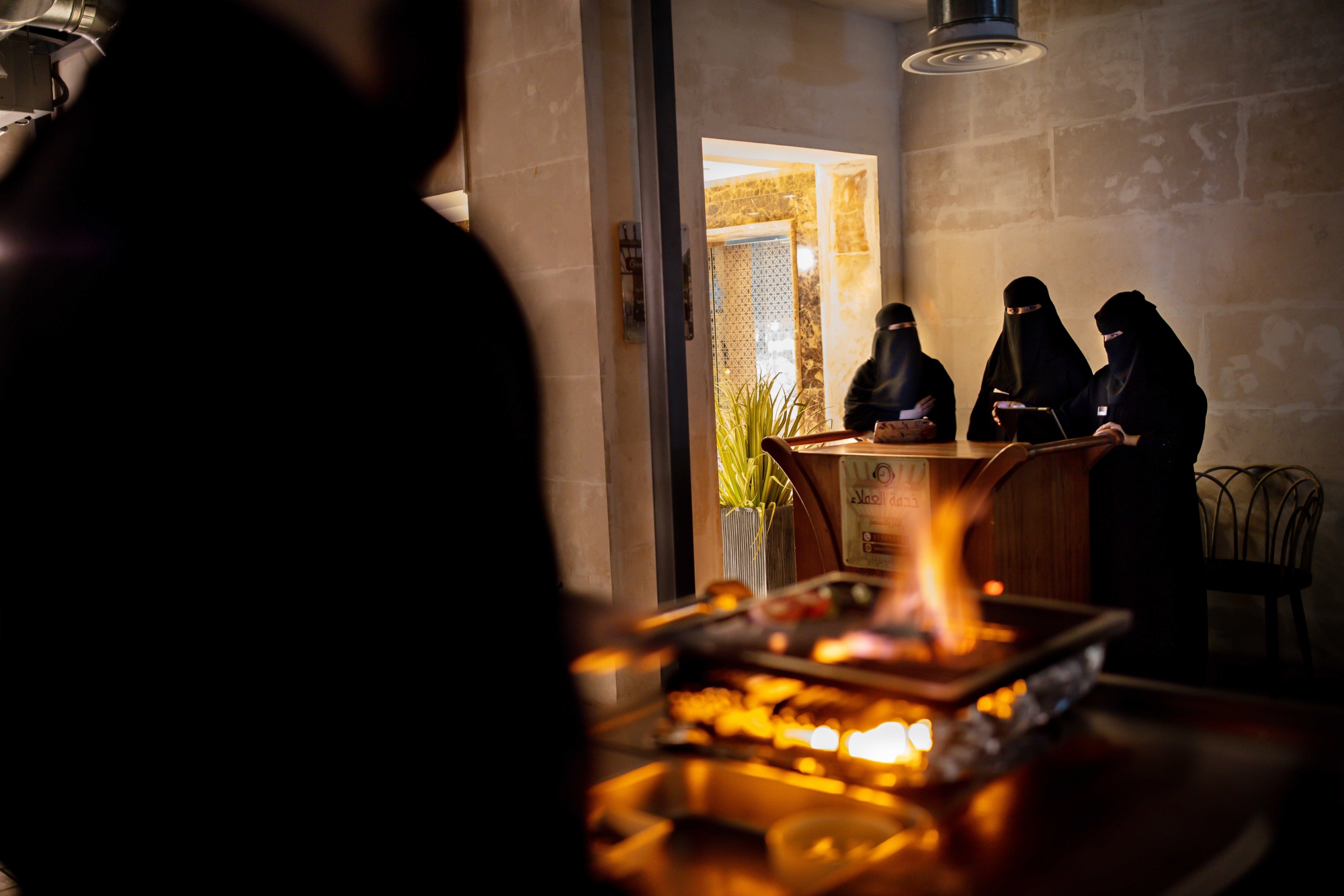 Saudi women work at the reception desk of a restaurant in Buraidah, Saudi Arabia.