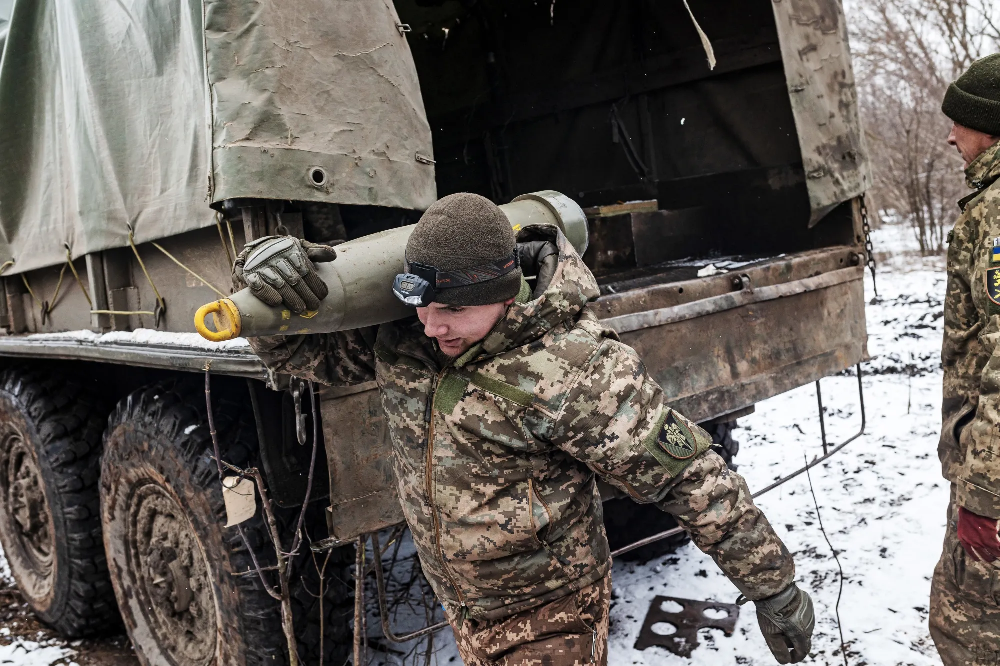 Ukrainian soldiers carry artillery shells at their fighting position in the direction of Bakhmut.