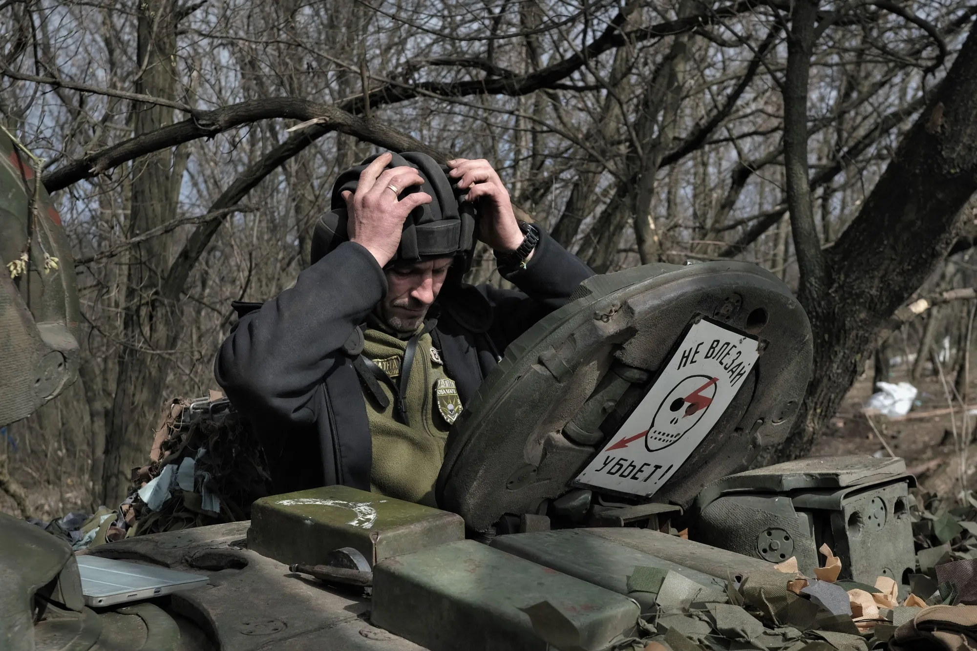 A Ukrainian serviceman enters a T-72 tank on the front line near Bakhmut.