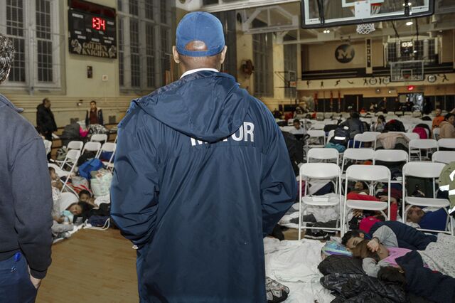 Then-New York City Mayor Eric Adams visits with asylum seekers taking shelter at a high school in Brooklyn in January 2024. 