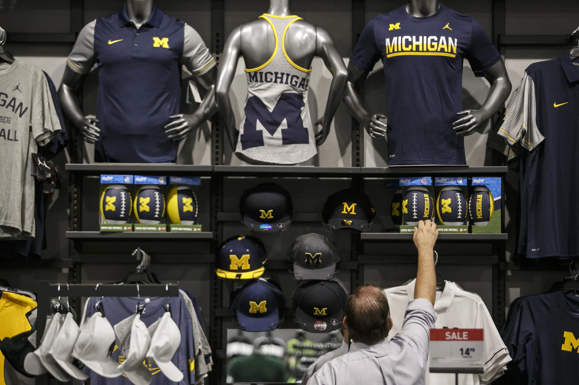 A customer reaches for University of Michigan branded merchandise at a store in Sterling Heights, Michigan.