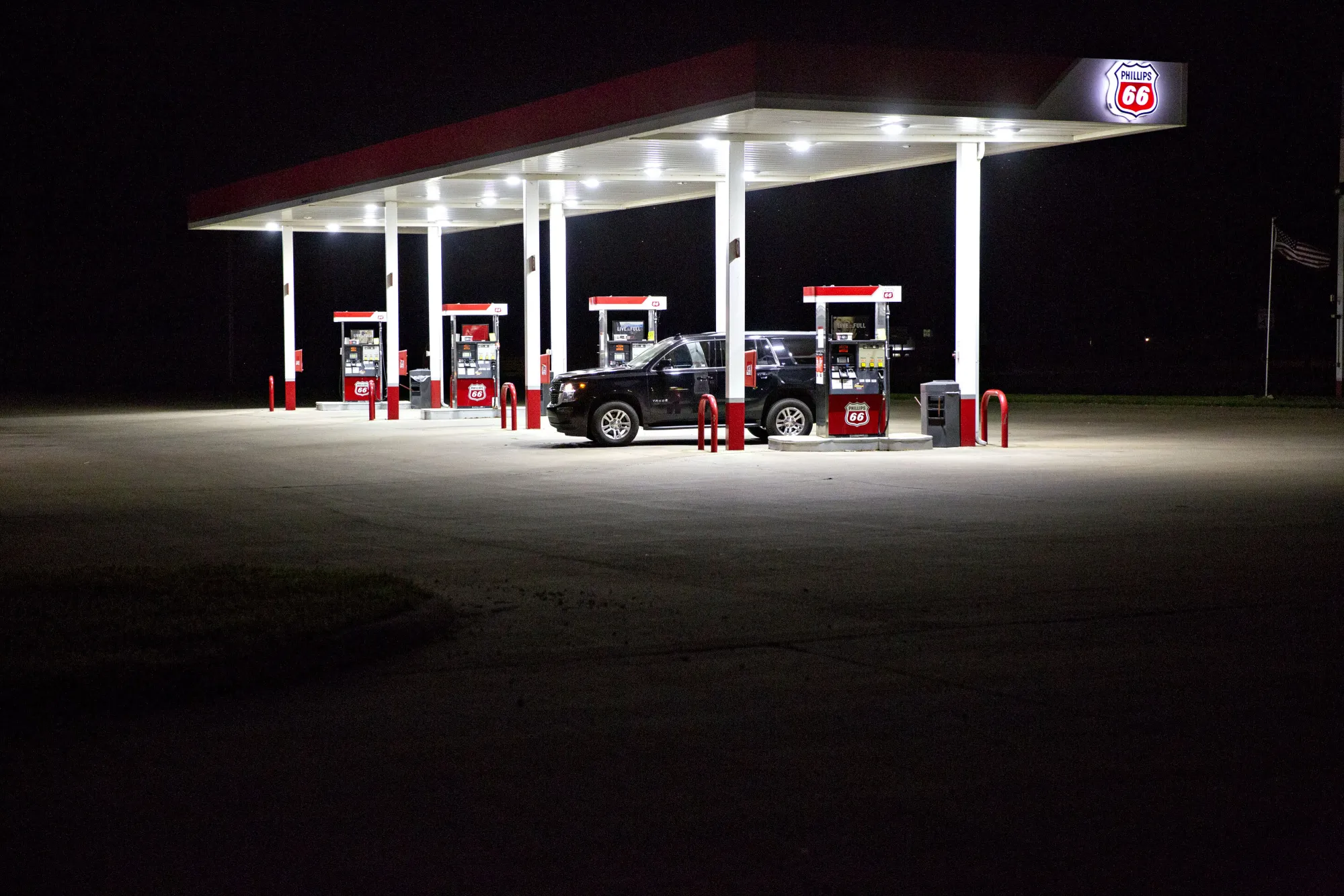 A customer fuels a vehicle at night at a Phillips 66 gas station in Henry, Illinois.
