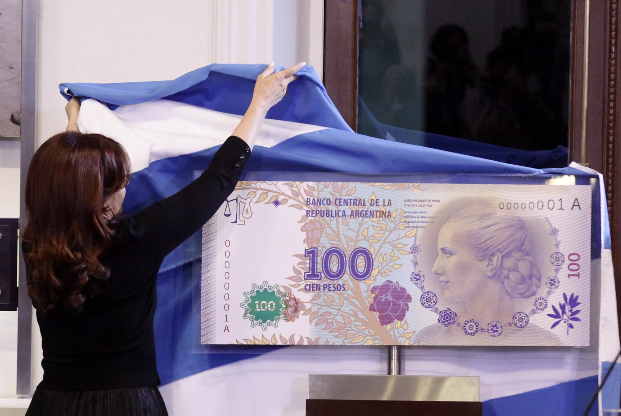 Argentina's former president Cristina Fernandez unveils an archetype of the 100 Argentine pesos bill bearing the profile of former late first lady Maria Eva Duarte de Peron in 2012. Photographer: Alberto Raggio/AP Photo
