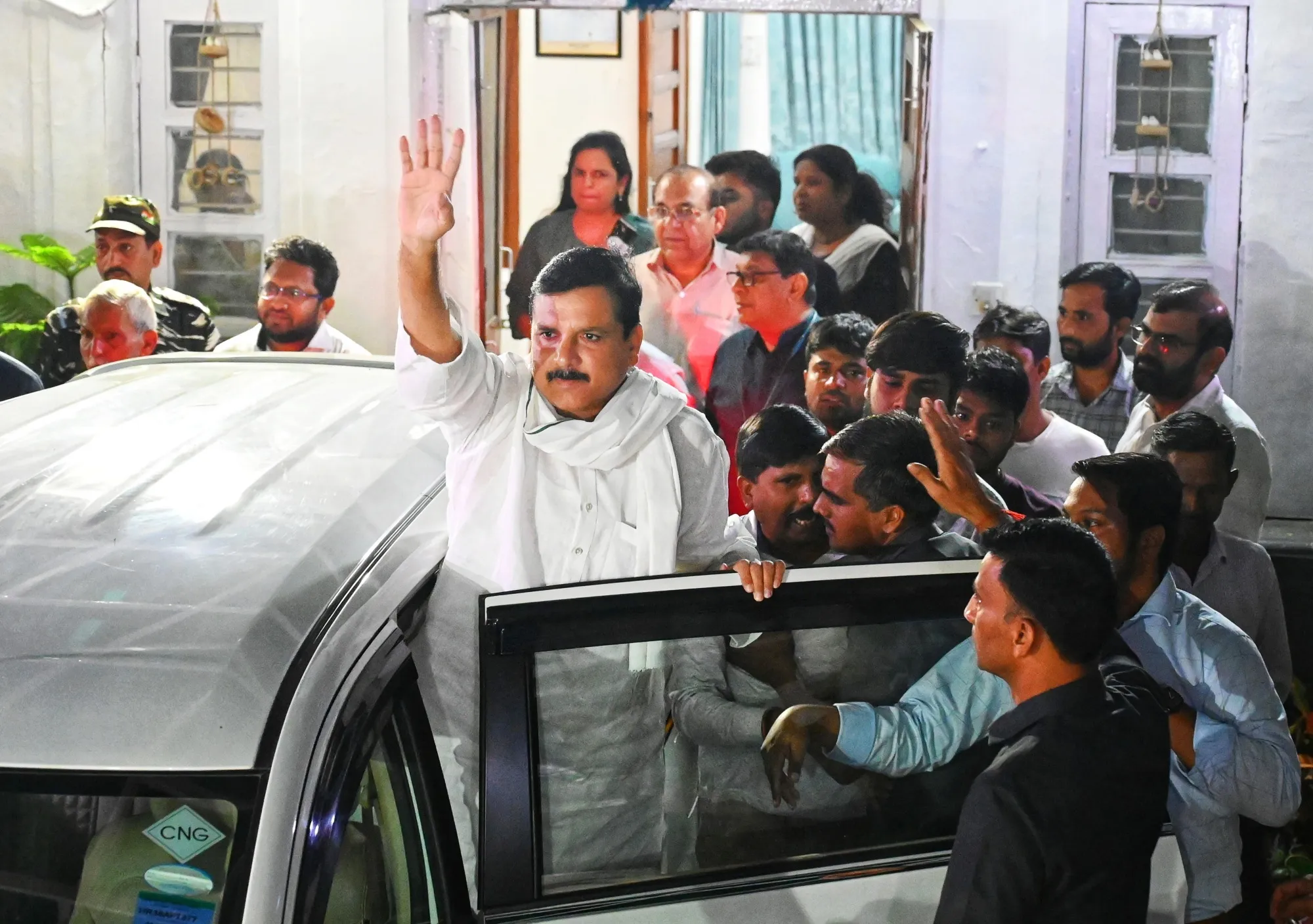 Sanjay Singh waves after being arrested in New Delhi on Oct. 4.