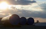Cyclists pass sections of pipeline at the halted construction site for the South Stream gas project in Sajkas, Serbia, on Sunday, June 15, 2014. Russia's Foreign Minister Sergei Lavrov arrives in Serbia today for a 2-day visit.