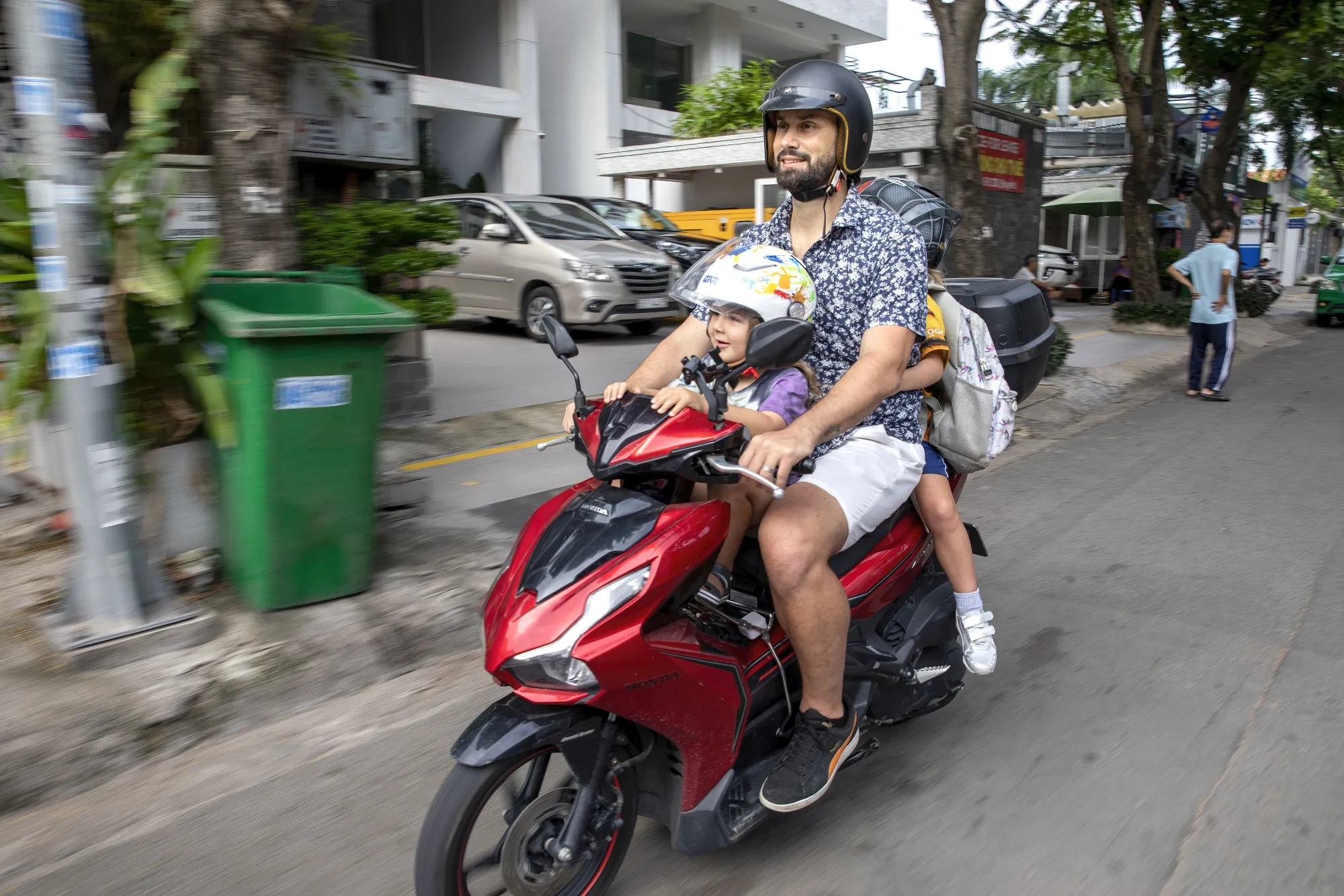 Vinnie Lauria takes his children to school by motorbike in Ho Chi Minh City.