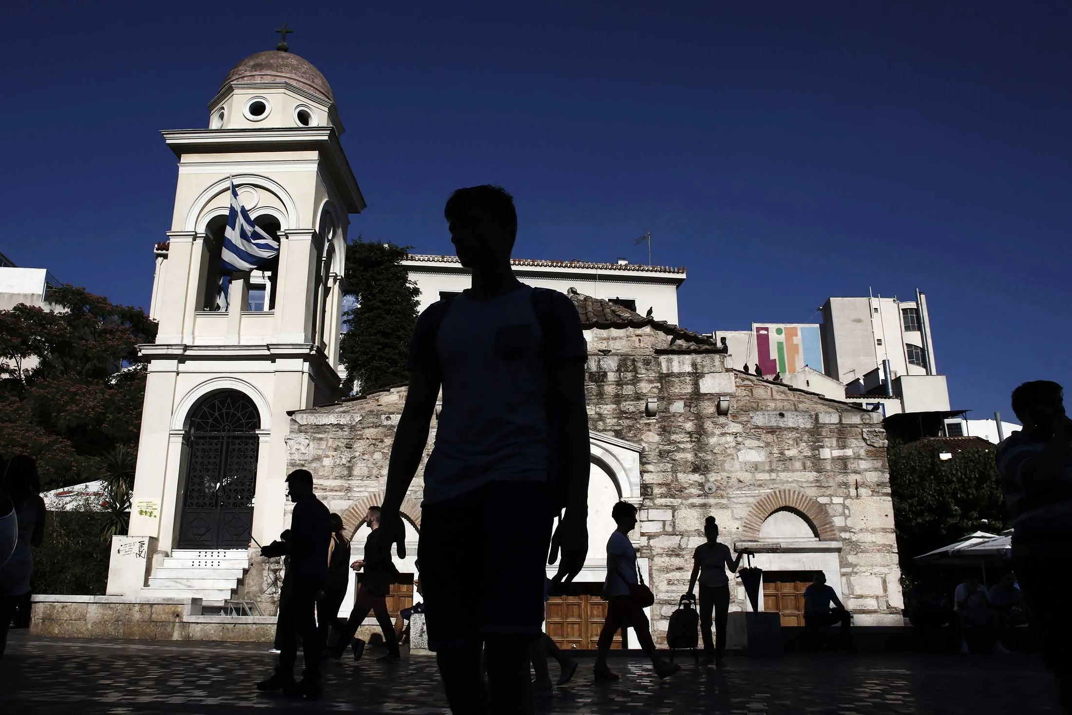 Pedestrians walk through Monastiraki square in Athens
