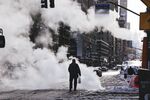 A pedestrian walks through snow on the street in New York, U.S., on Thursday, Dec. 17, 2020.