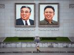 A person walks beneath portraits of Kim Il-sung and Kim Jong-il displayed in Kim Il-sung Square in Pyongyang.