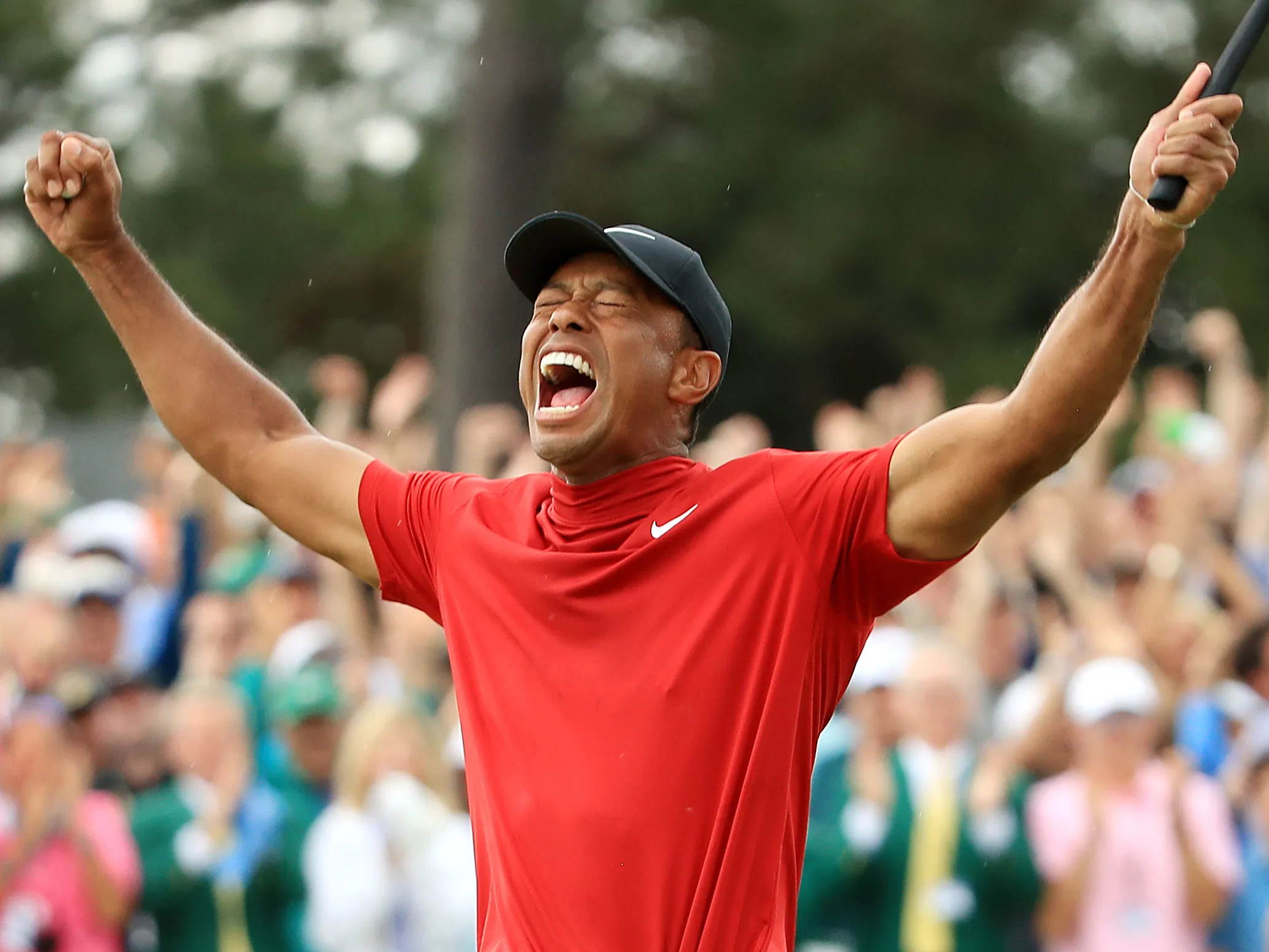 Tiger Woods celebrates after sinking his putt on the 18th green to win during the final round of the Masters.