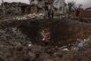 A woman stands in a crater following a Russian missile attack near Kyiv in January.
