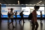 Commuters walk past an advertisement for Ant Group Co.'s payments app&nbsp;Alipay at a subway station in Shanghai, China.