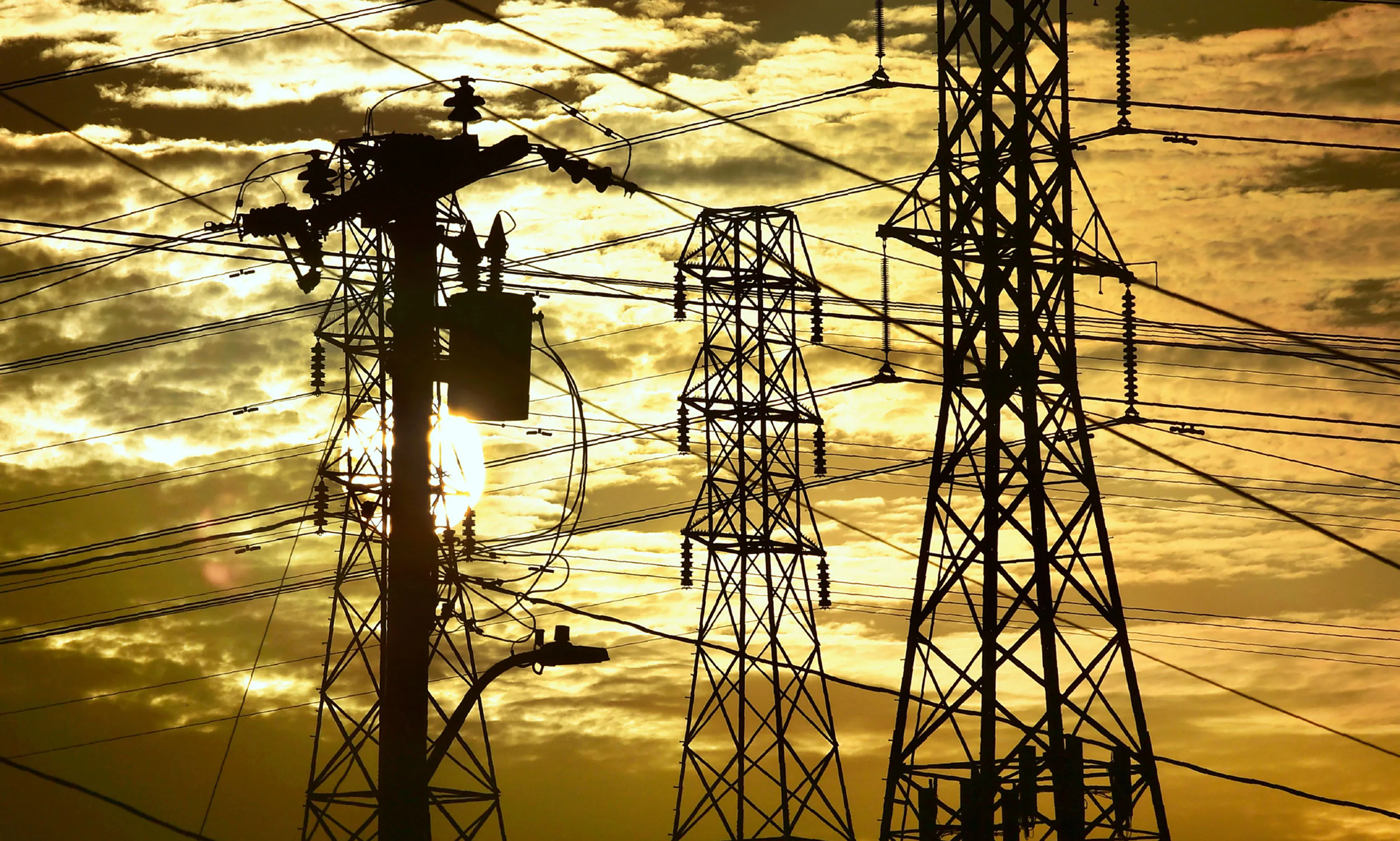 The sun sets behind power lines and poles in Rosemead, California.&nbsp;