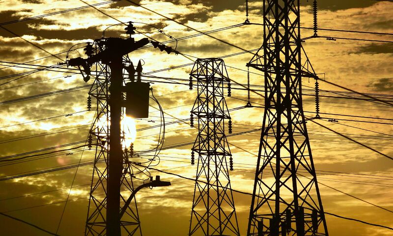 The sun sets behind power lines and poles in Rosemead, California.Â 