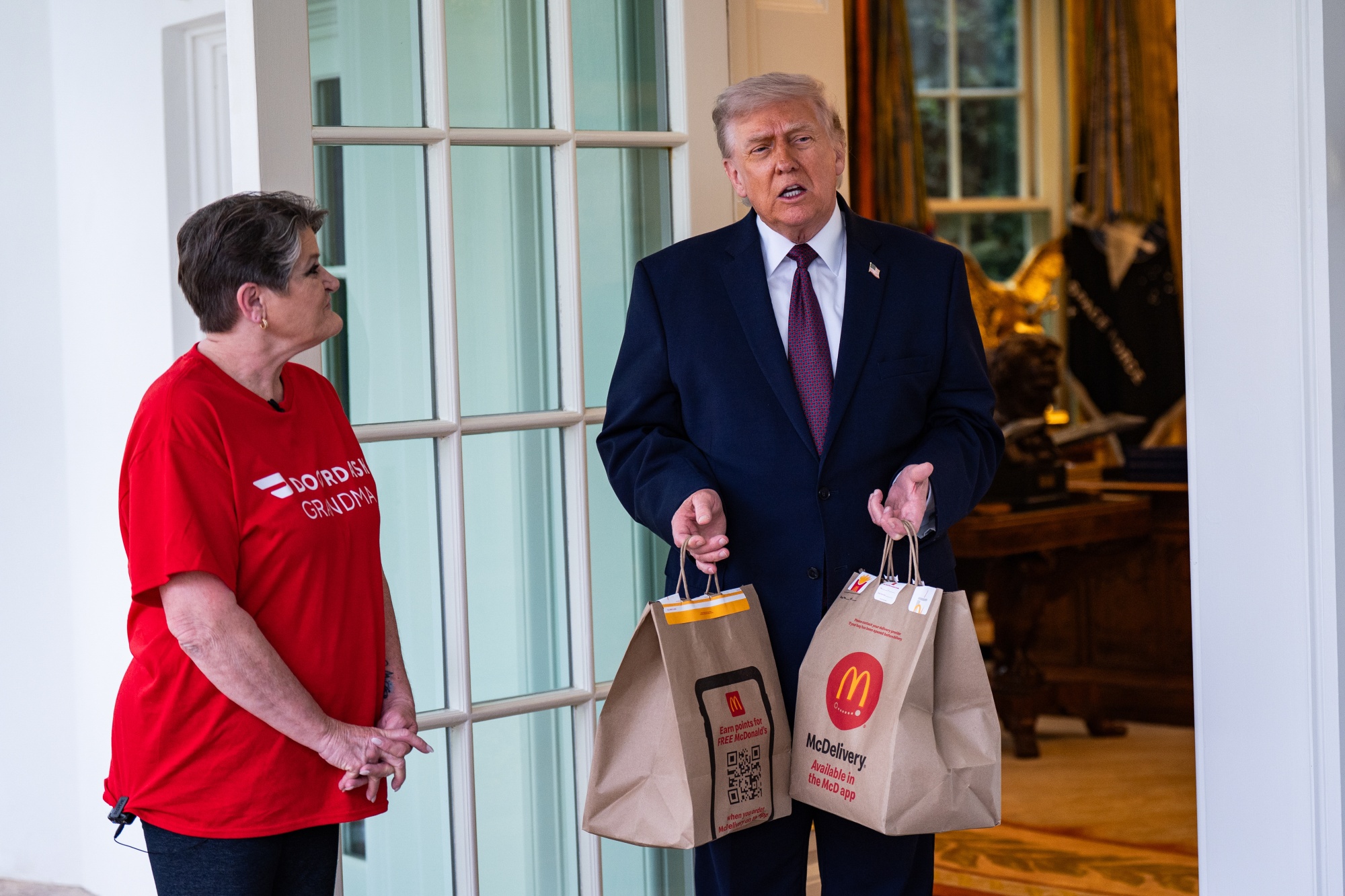 US President Donald Trump receives a McDonald's food order from Sharon Simmons, a DoorDash worker, outside the Oval Office of the White House in Washington, DC, US, on Monday, April 13, 2026. Trump is highlighting the "No Tax on Tips" policy, which allows eligible workers to deduct qualified tips from their federal income taxes as part of the One Big Beautiful Bill Act. Photographer: Salwan Georges/Bloomberg
