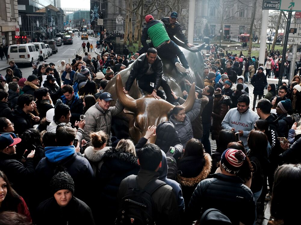 People congregate at the Charging Bull in lower Manhattan.