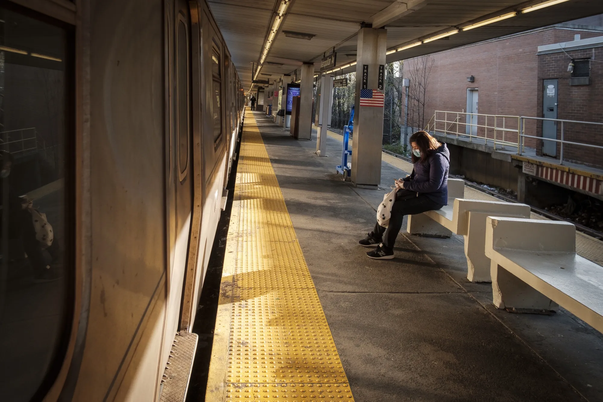 A commuter wearing a protective masks waits for a subway at the Metropolitan Avenue M station in the Queens borough of New York on&nbsp;April 7.