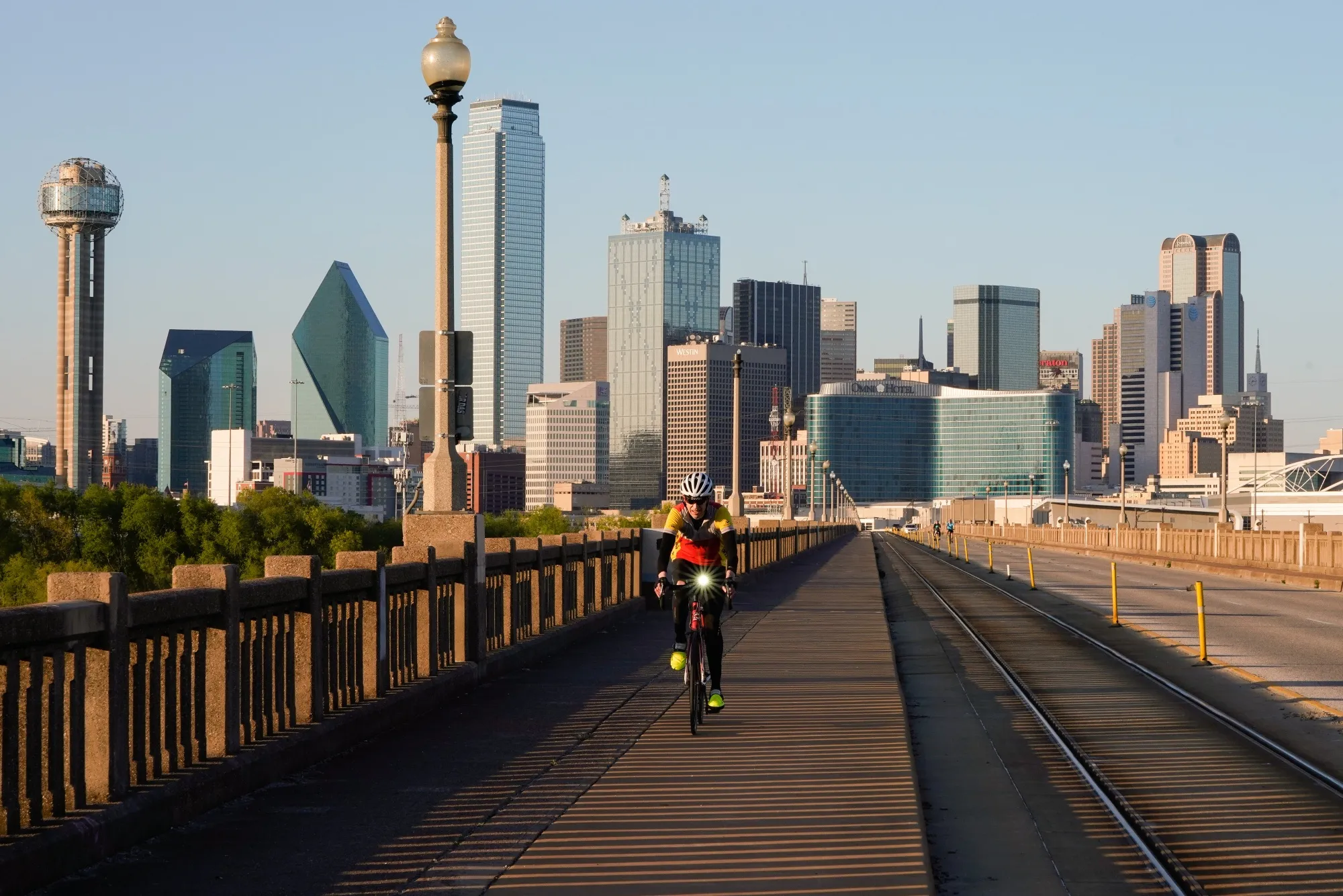 A person rides a bicycle along a nearly empty Houston Street Viaduct in Dallas, Texas.
