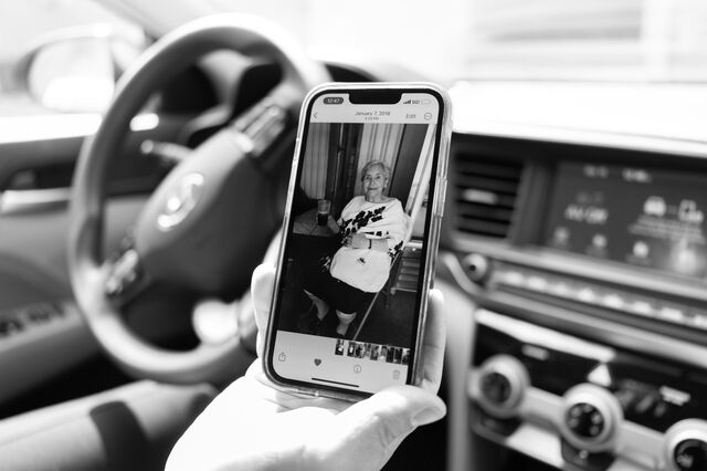 Ovares looks at photograph of her late grandmother on her cellphone inside her car. 