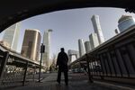 A pedestrian passes buildings in Beijing, China. Photographer: Qilai Shen/Bloomberg