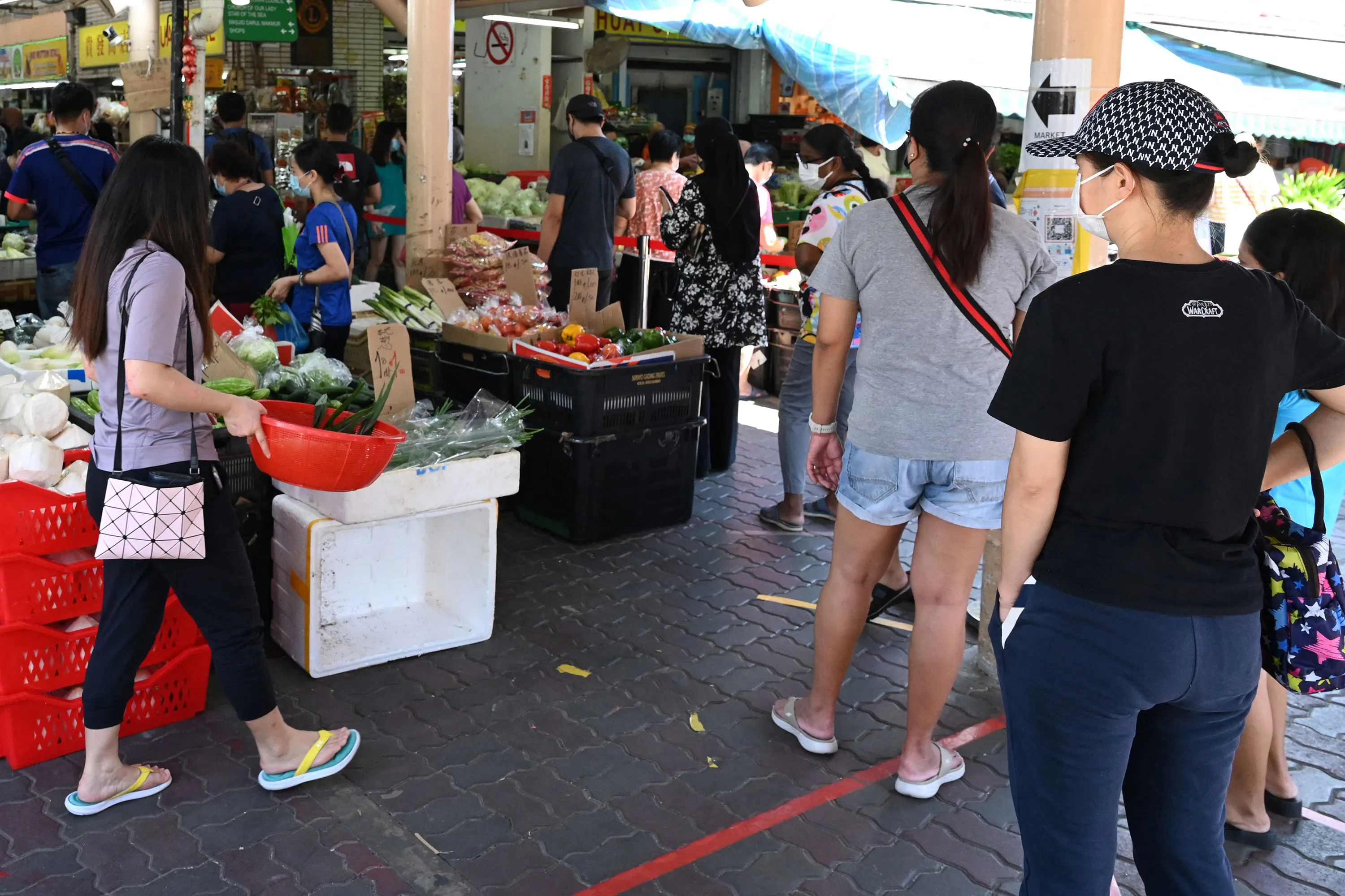 People queue to enter a market in Singapore.