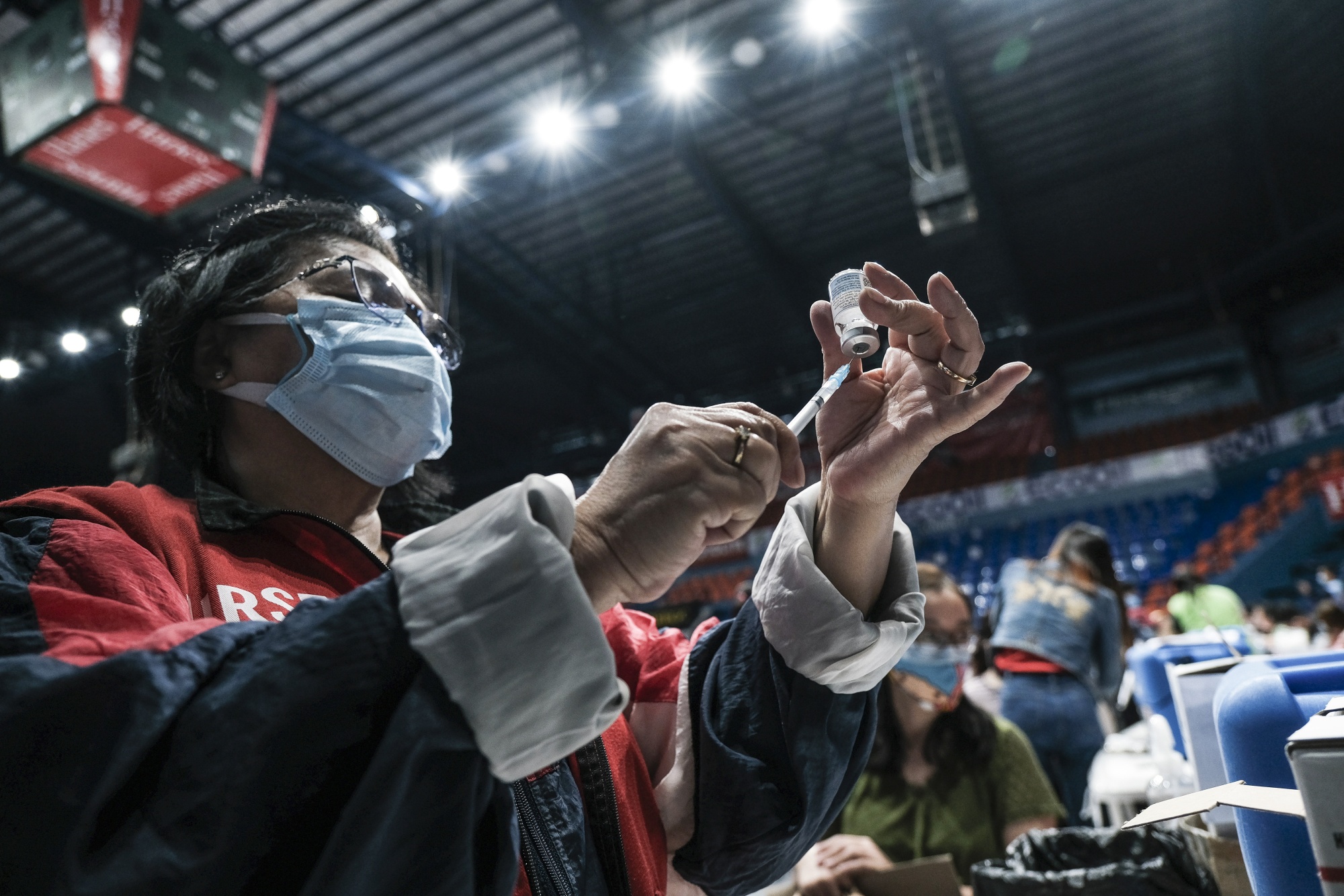 A health worker prepares a dose of the Moderna Covid-19 vaccine at a vaccination site inside a gymnasium in San Juan City, Metro Manila, on Dec. 28, 2021.